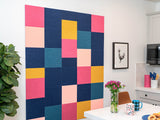 Colorful geometric wall art in a kitchen setting with a plant and table.