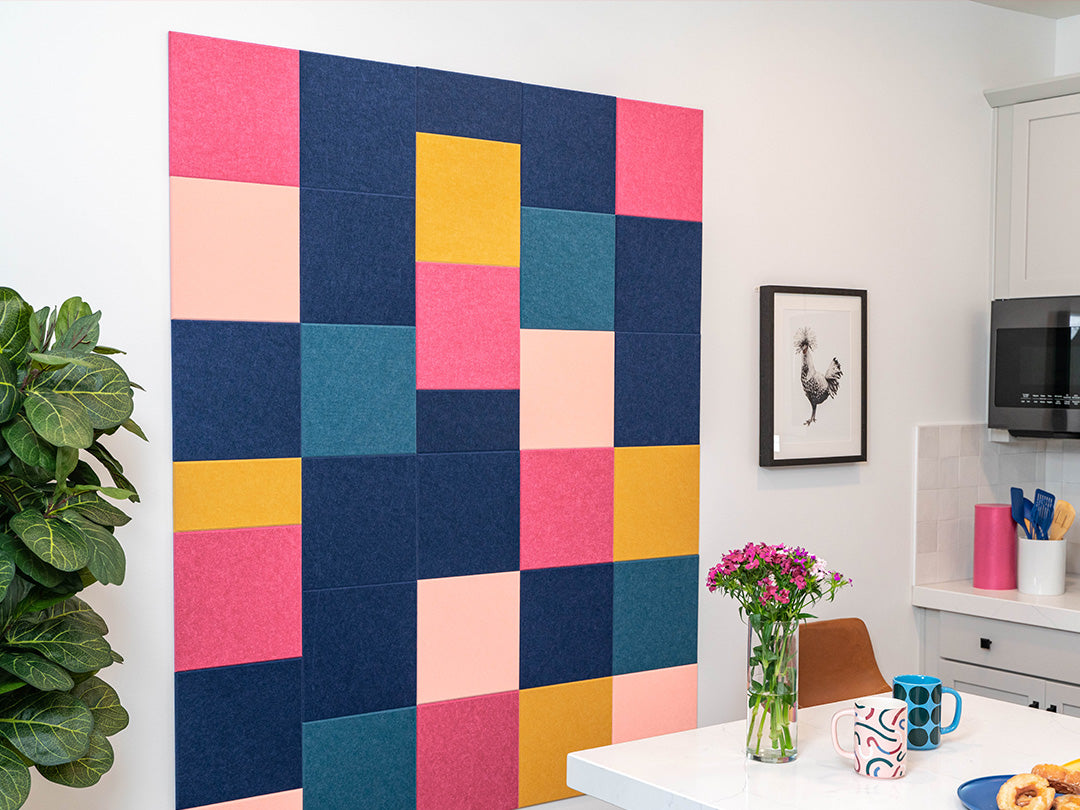 Colorful geometric wall art in a kitchen setting with a plant and table.