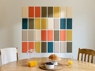 Color swatch wall art in a kitchen with a table set for breakfast.