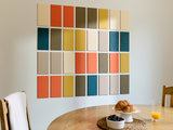 Color swatch wall art above a dining table with food and drinks.