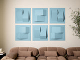Six light blue textured wall panels with geometric shapes and cutout details arranged in a grid above a tan sofa.