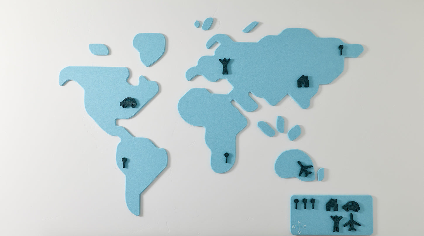 Blue world map wall art with reposition-able pieces on a white background