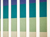 A Felt Right Wall Design in blues, greens, and creams felt tiles in a pattern on a light wall with negative space