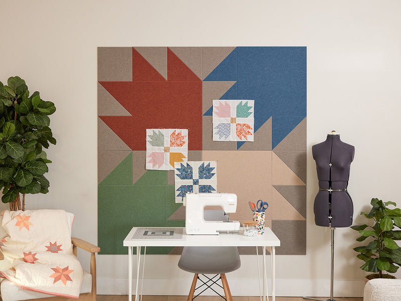 Sewing room with a sewing machine, mannequin, and colorful quilt design wall art.