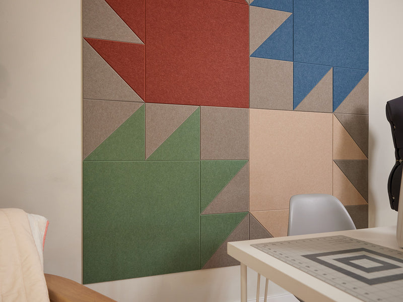 Sewing room with a sewing machine, mannequin, and colorful quilt design wall art.