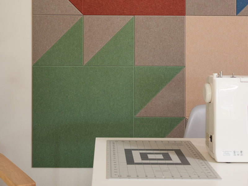 Sewing room with a sewing machine and colorful quilt design wall art.