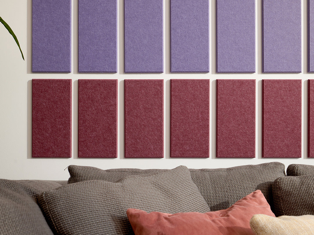 A Felt Right wall art design in shades of purple felt rectangles in an ombre pattern above a couch.