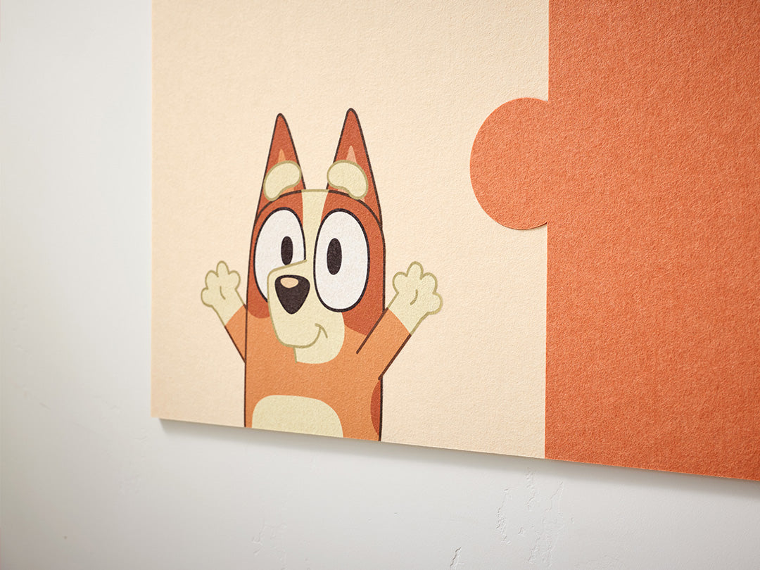 Cartoon Bingo character on a wall with orange and beige background