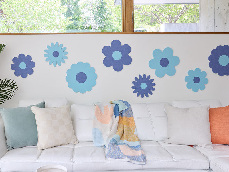 White sofa with colorful cushions and flower decals on a wall