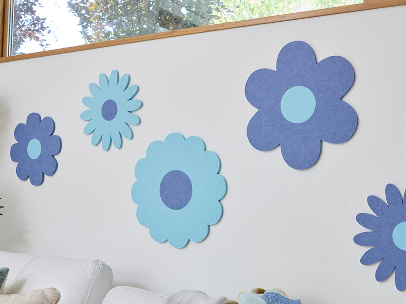 White sofa with colorful cushions and flower decals on a wall