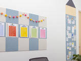 Felt board with colorful magnetic markers and a wall with pinned papers in an office setting.