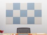 Checkered acoustic panel on a wall above a desk with office supplies.
