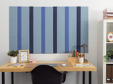 Blue and dark pinstriped bulletin board mounted on white wall above wooden desk.