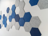 A Felt Right wall design on a wall adorned with a pattern of blue and gray hexagonal tiles on a white wall