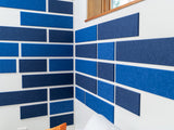Blue shiplap boards with white spacing installed on corner walls in varying shades of blue and navy.