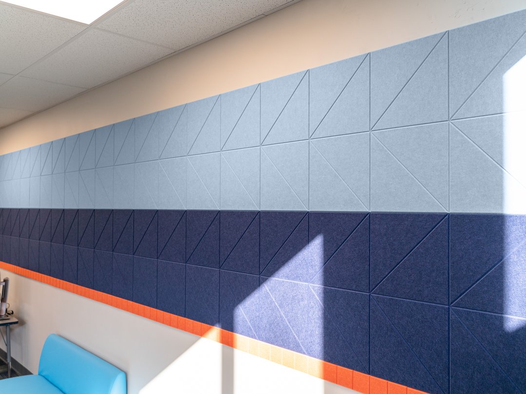 Felt Right wall art design in a classroom in shades of blue and orange creating a stripe across a wall.