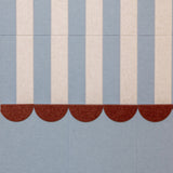 Textile pattern with vertical stripes and a scalloped edge on a blue background
