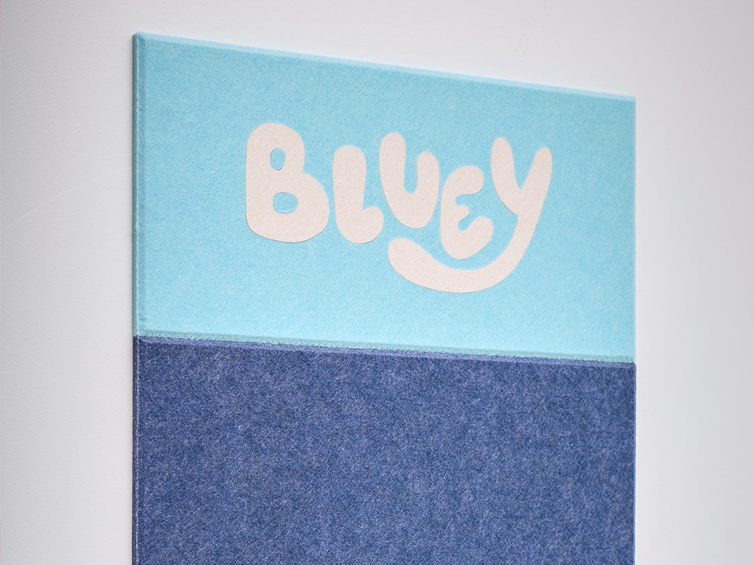 Felt wall tile with 'Bluey' text on a light blue and dark blue background