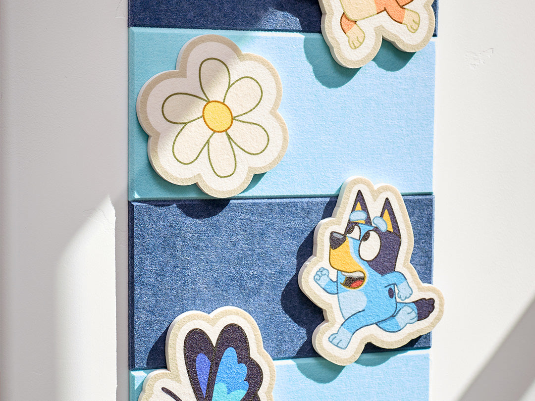 Set of colorful pieces with a cartoon Bluey character and floral design on a blue felt background