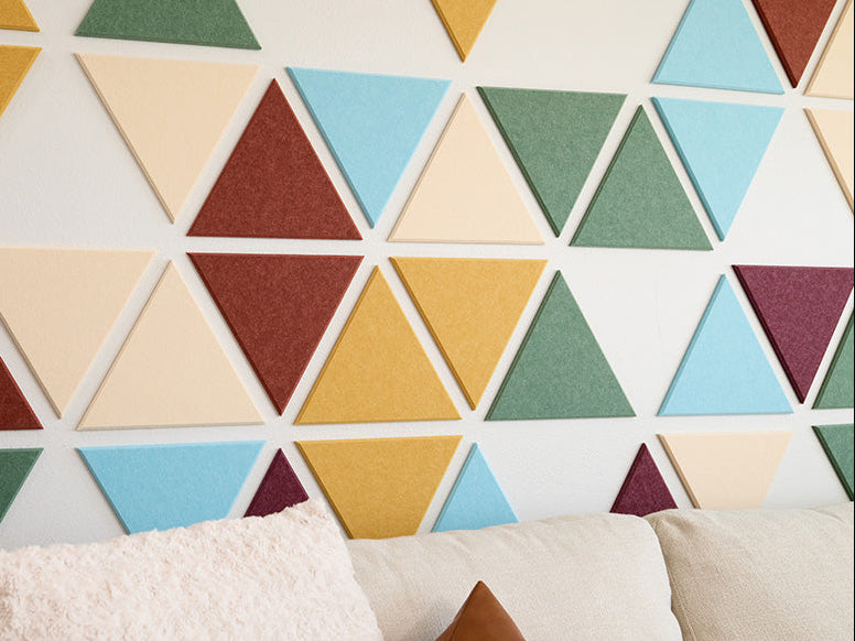 Colorful geometric triangle-patterned wall panels in a living room setting.