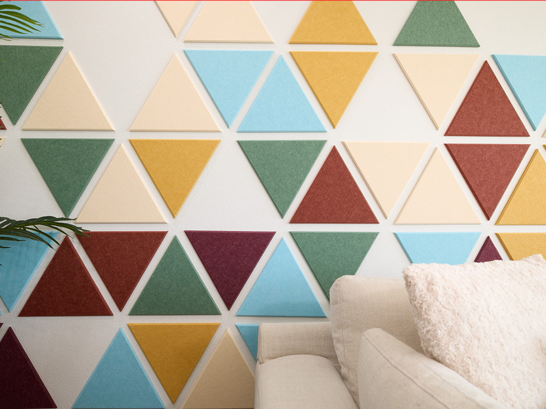 Colorful geometric triangle wall panels in a room with a sofa.