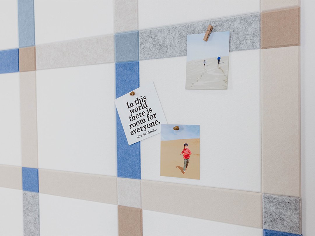 Felt Right wall art design using shades of blue, grey, and cream to created a plaid pattern. Pictures pinned on it.