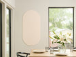 Dining room with a table set for a meal, featuring a vase of flowers and a Felt Right wall art design in the shade of green