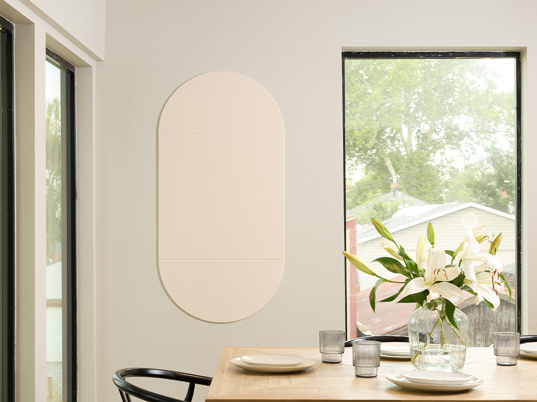Dining room with a table set for a meal, featuring a vase of flowers and a Felt Right wall art design in the shade of green