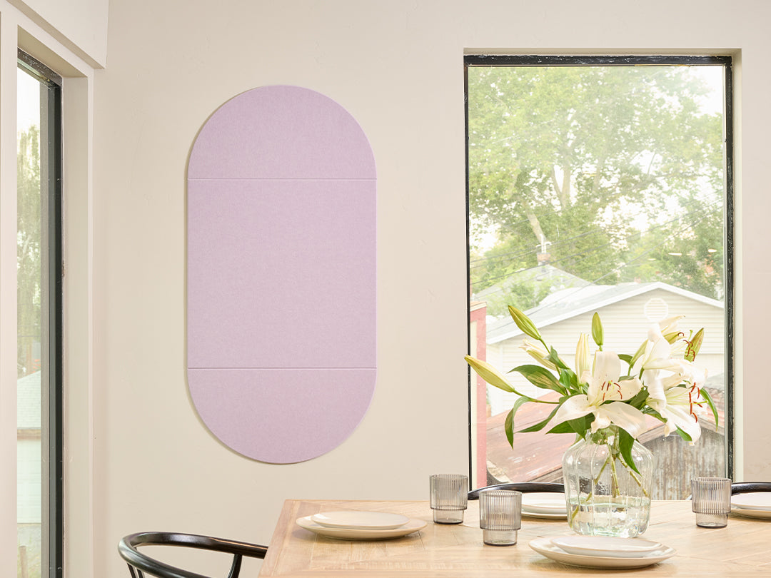 Dining room with a table set for four, a vase of flowers, and a purple Felt Right  wall art piece.