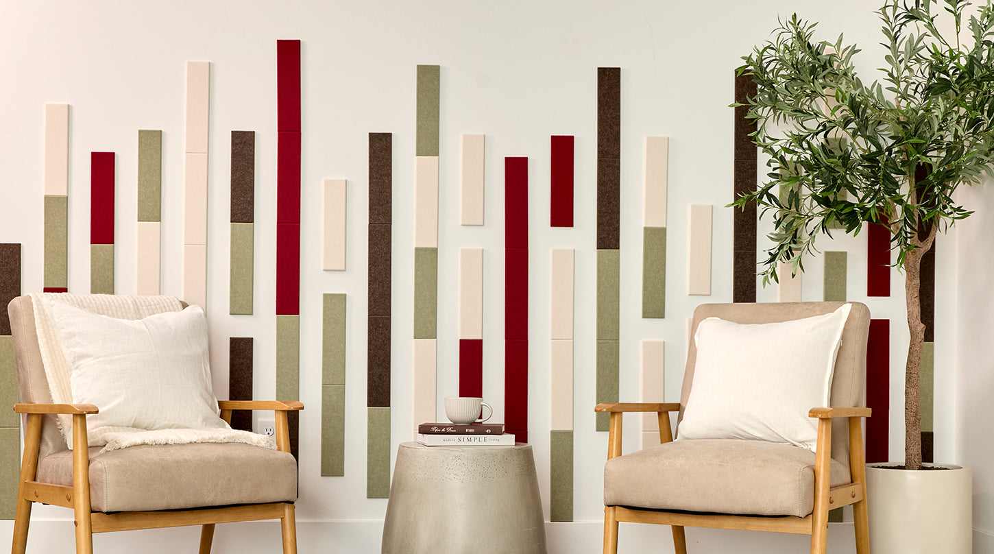 Two beige armchairs with wooden frames in front of a wall with vertical acoustic panels