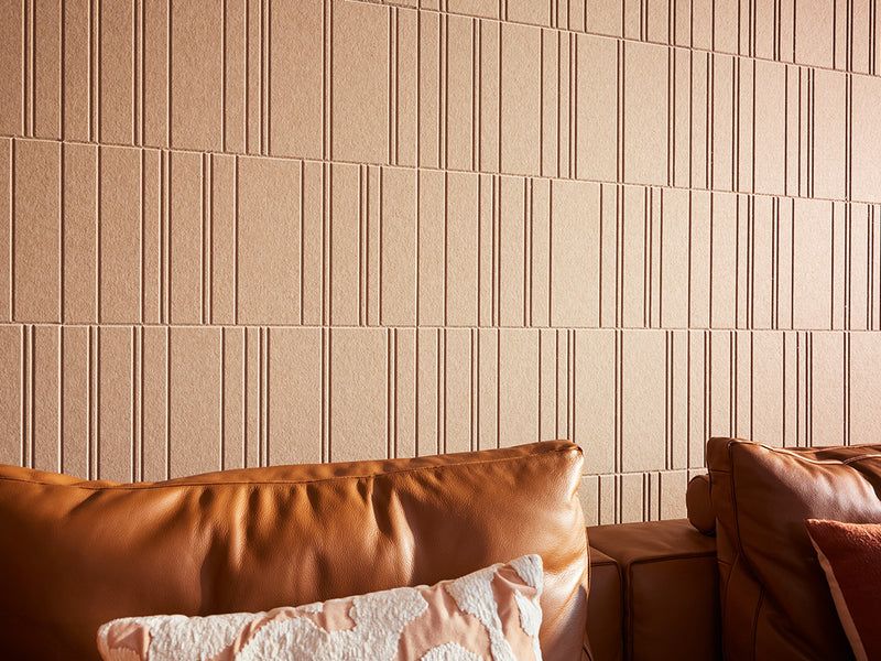 Brown engraved wall tiles above leather couch