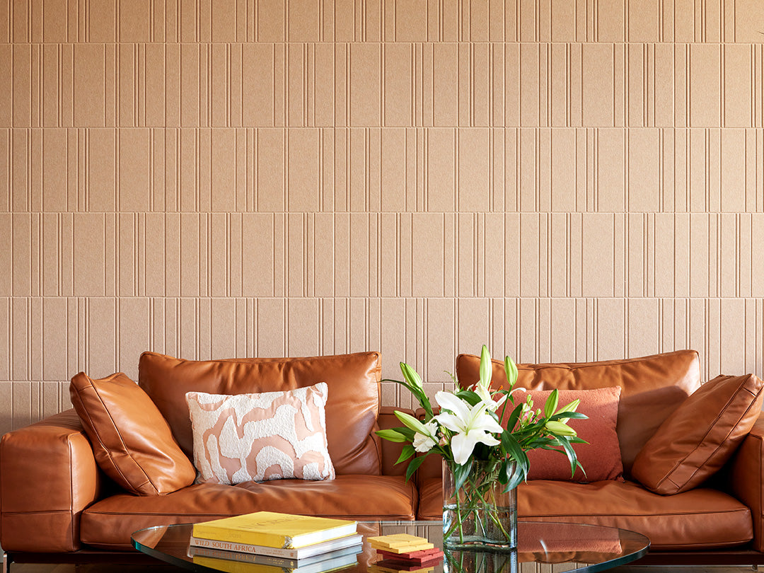 Brown engraved wall tiles above leather couch