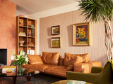 Brown engraved wall tiles with frames above leather couch