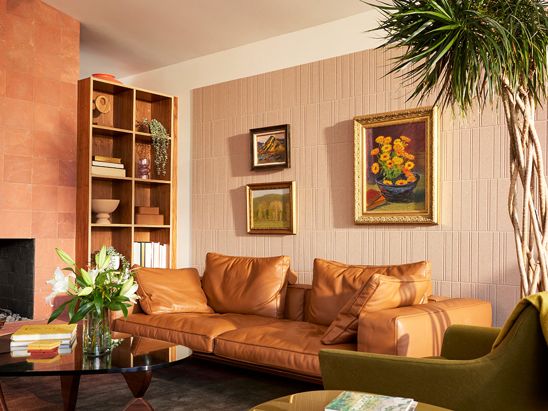 Brown engraved wall tiles with frames above leather couch