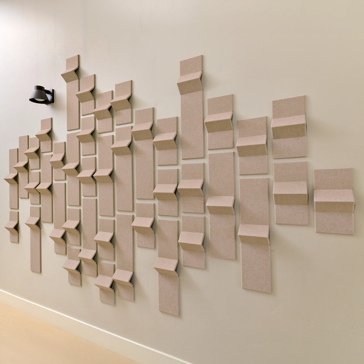 Tan felt acoustic tiles with points of dimension to create a modern design