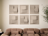 Six beige textured tiles with geometric cutouts and dimensional relief patterns mounted on wall above tan sofa.