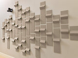 Beige three-dimensional wall tiles arranged in staggered pattern creating a textured geometric surface installation.