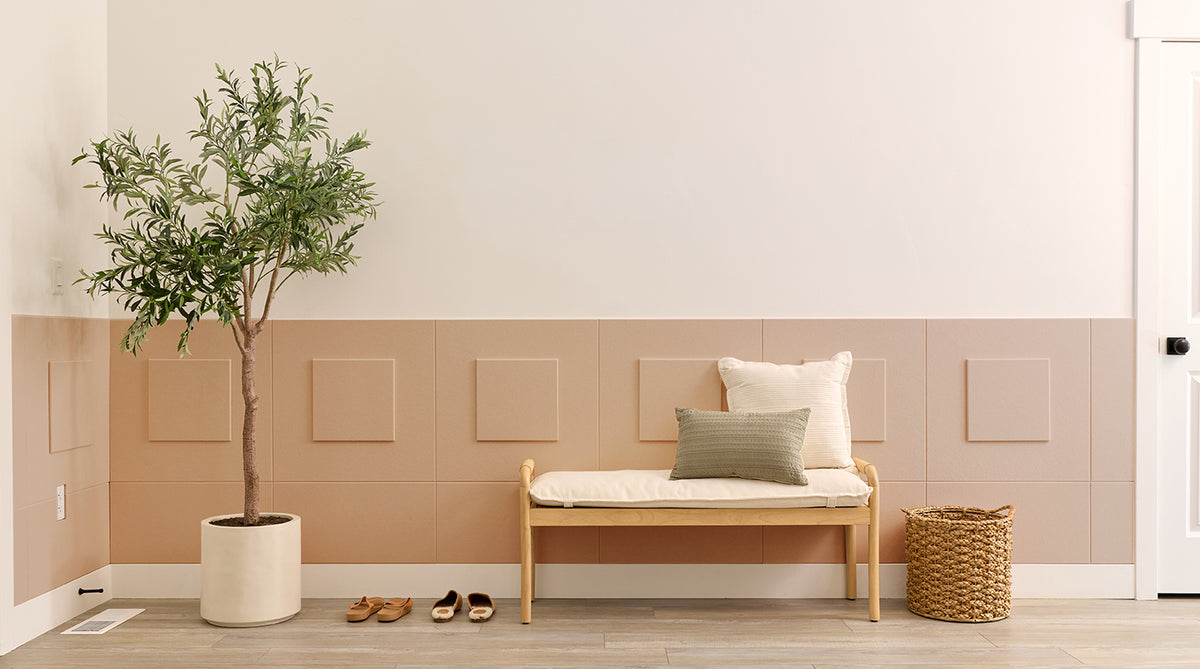 Wainscoting in entryway with a bench and tree.