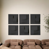 Dark grey acoustic felt tiles that are 3D on a wall above a couch