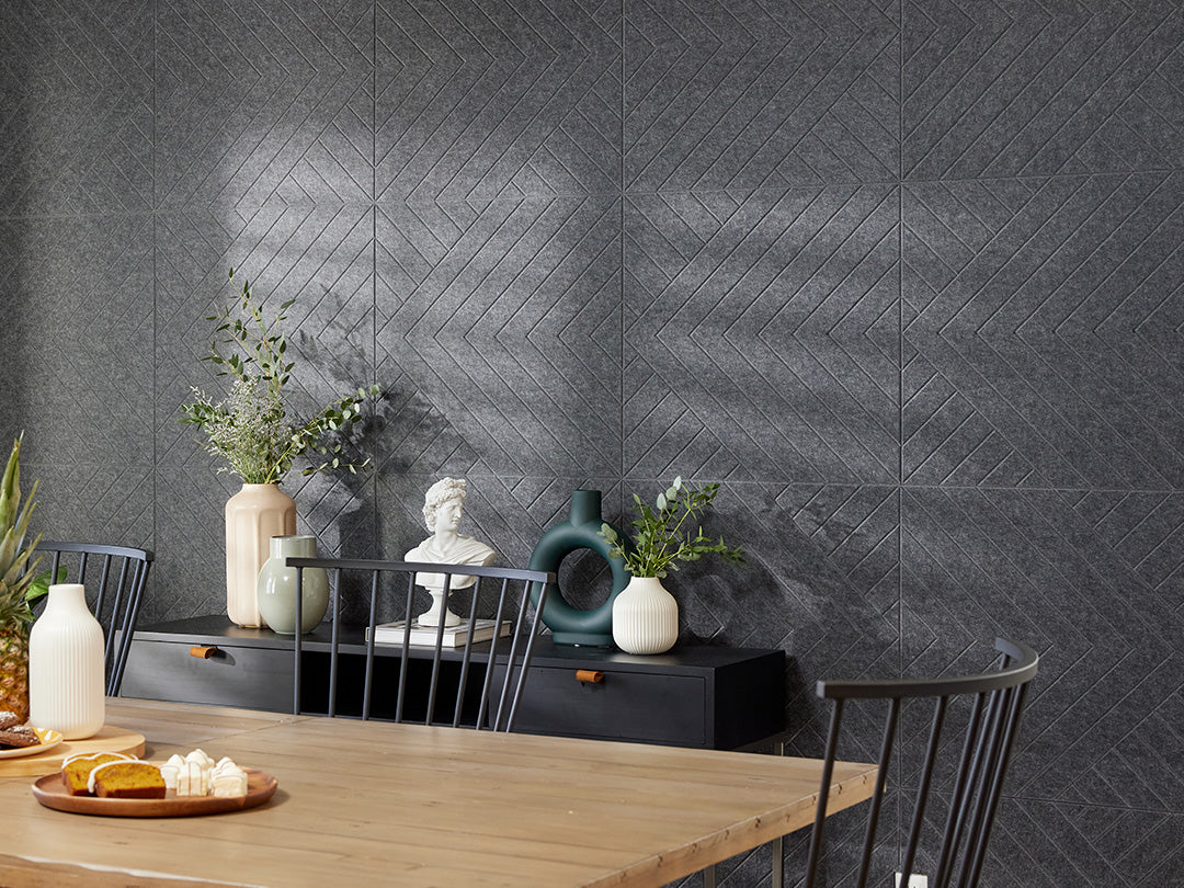 A Felt Right wall art design in a dark shade of grey on a kitchen wall next to a dinning table