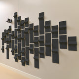 Dark grey acoustic tiles made of felt with peak dimensions on a wall
