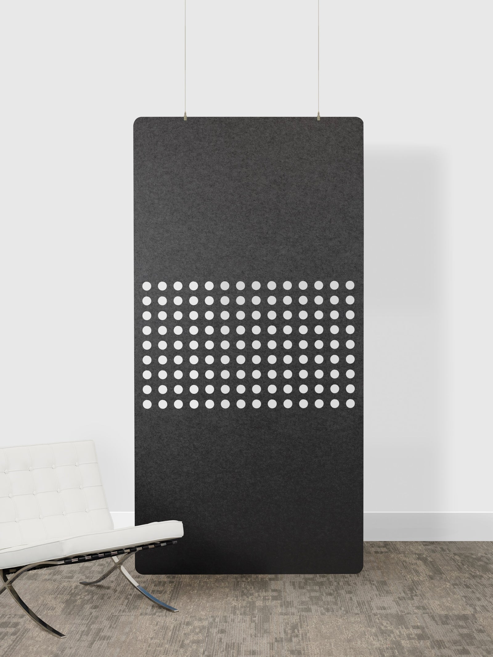Black acoustic panel with white dot pattern on a white wall
