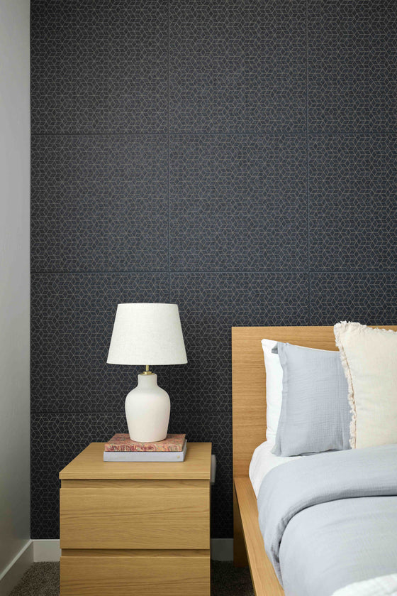 Bedroom with dark patterned wallpaper, wooden nightstand, and bed with pillows.