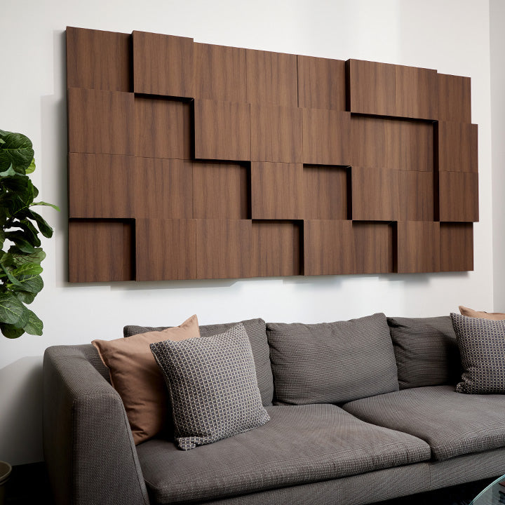 Walnut wooden acoustic boxes installed on white wall above couch