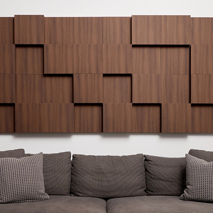 Walnut wooden acoustic boxes installed on white wall above couch
