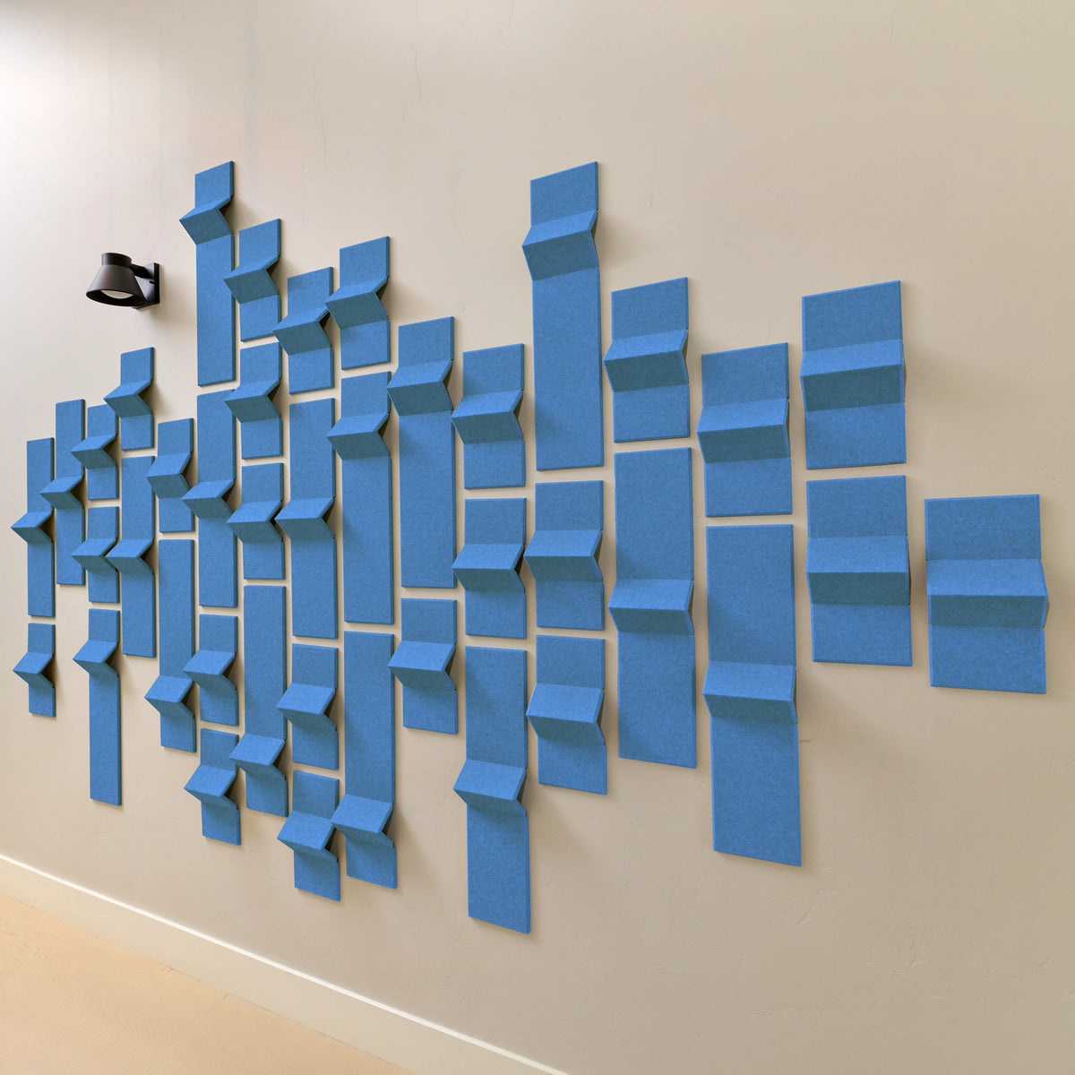 Bright blue acoustic tiles on a wall with a modern design