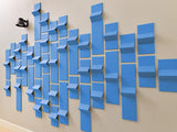 Blue three-dimensional modular tiles arranged in an abstract wall installation with varying depths and shades.
