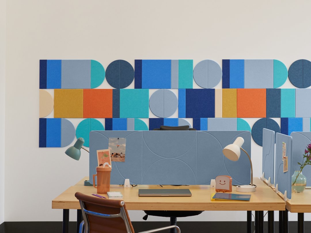 Felt Right wall art design on a white wall behind a desk in an office space. Felt tiles making a geometric wall art design.