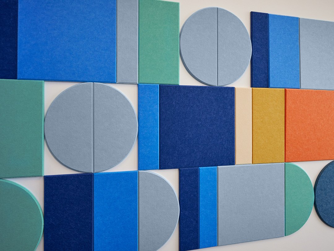 Felt Right wall art design with shades of blue and orange creating a geometric pattern on a white wall.