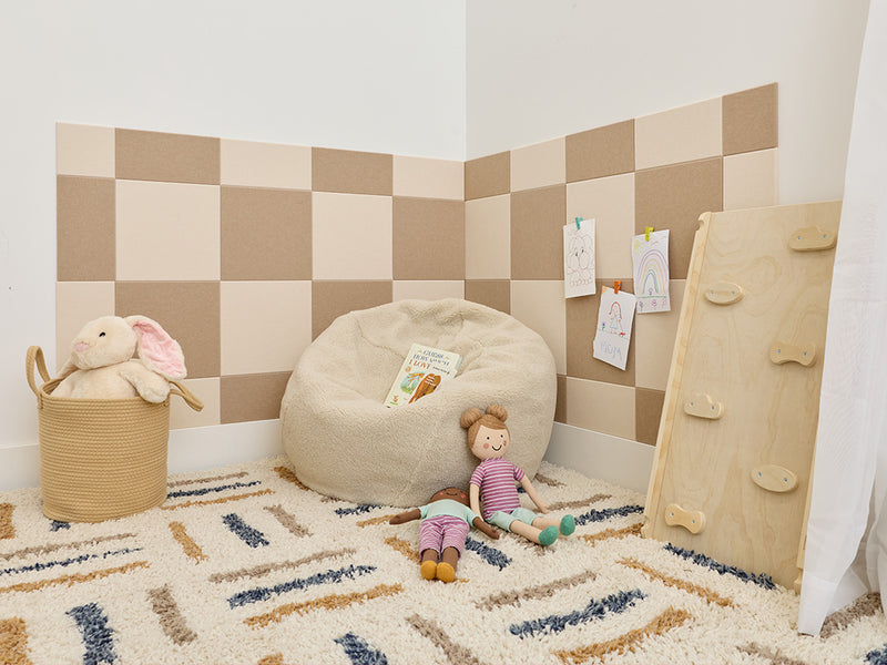 Children's playroom with checkered wall, bean bag, toys, and a basket.